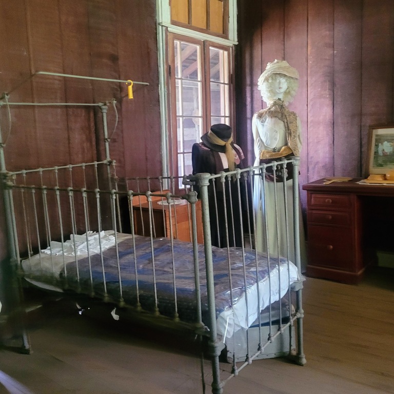 old bed and dummies in old fashioned dress at Historic Boondooma Homestead Qld