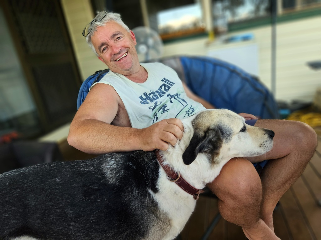 man in chair with 3 legged dogs head on lap  3 month farm sit around Australia Aussie house sitters