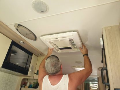 Larry installing our IBIS 4 Air conditioner in our caravan